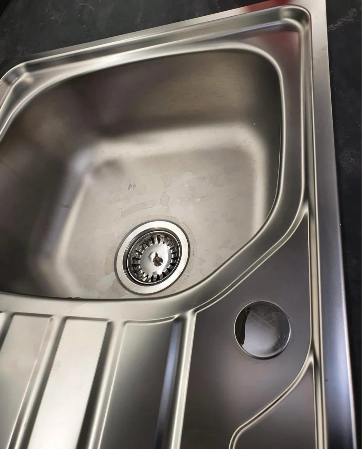 Scratched and worn stainless steel sink before refinishing